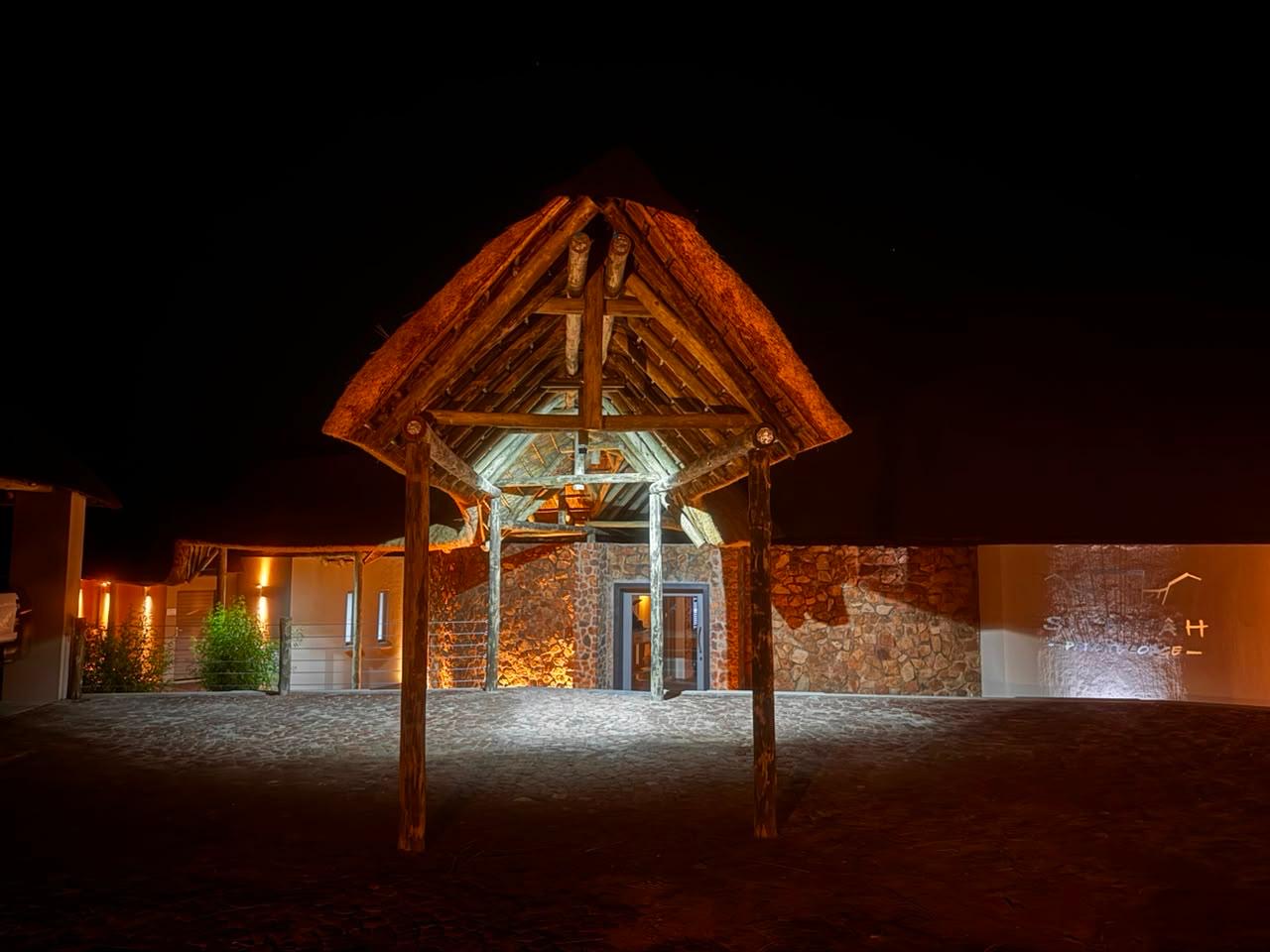 Thatched entrance portico of Sithrah Private Lodge lit at night