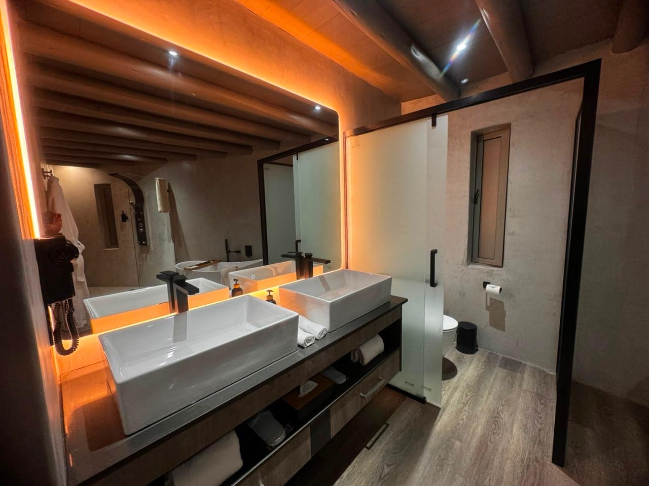 Twin vessel basins beneath a backlit mirror in a Sithrah Private Lodge bathroom