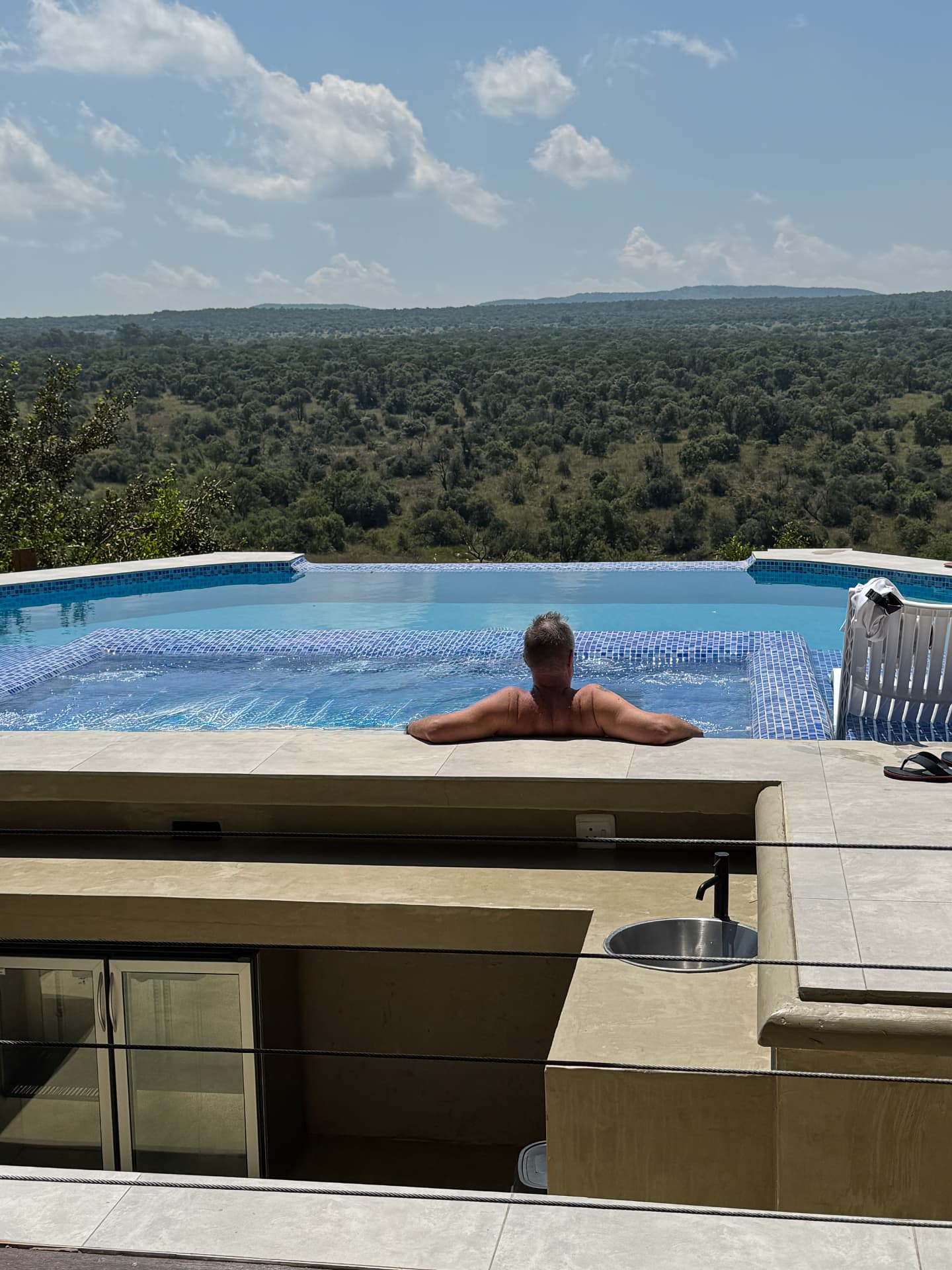 Guest relaxing in the jacuzzi at Tebuah Private Lodge looking over the Waterberg bushveld