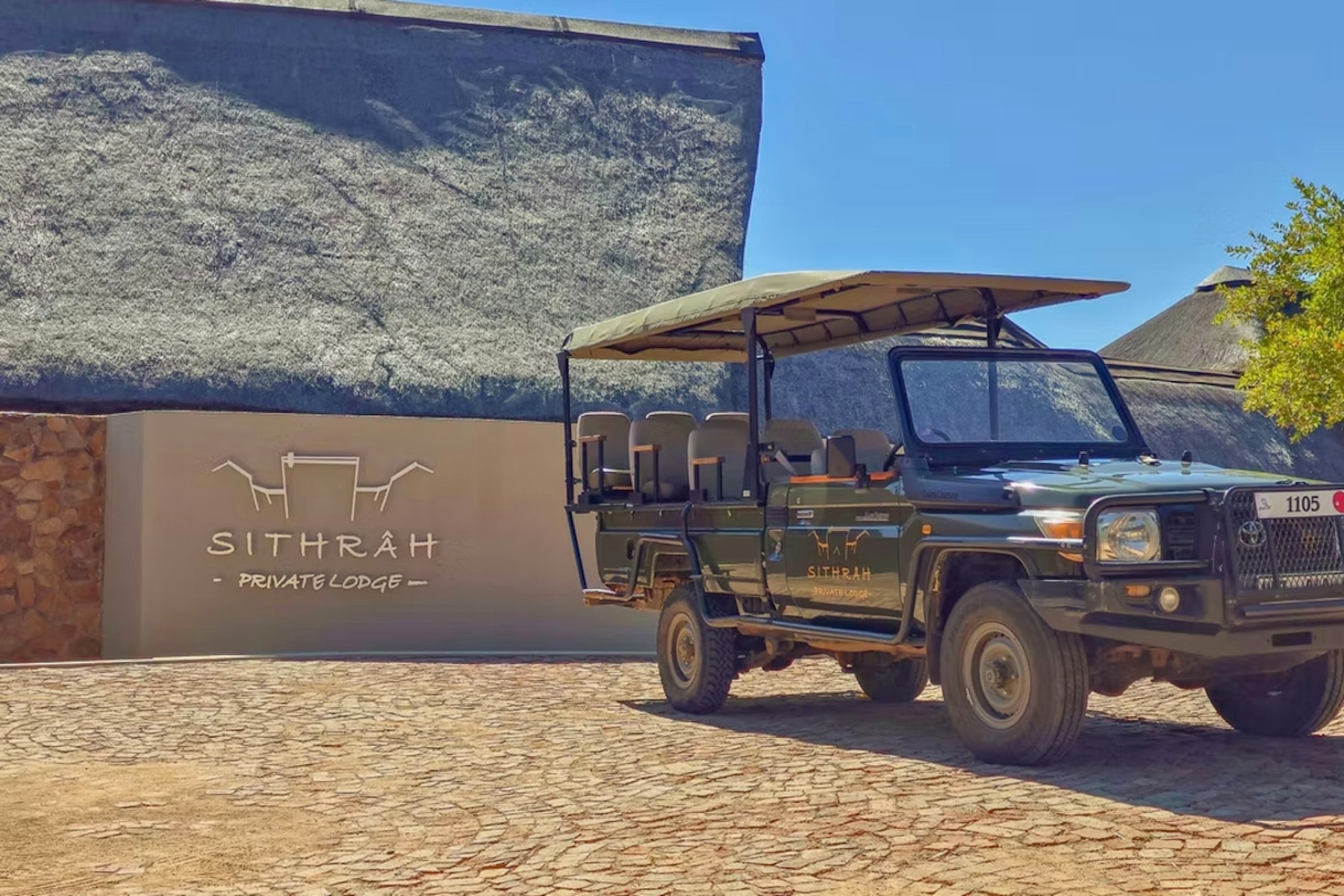 Sithrah Private Lodge entrance sign beside the open game viewing vehicle