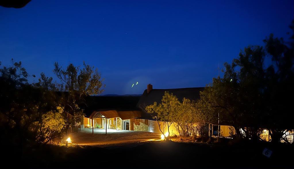 Sithrah Private Lodge glowing among the trees under a deep blue evening sky