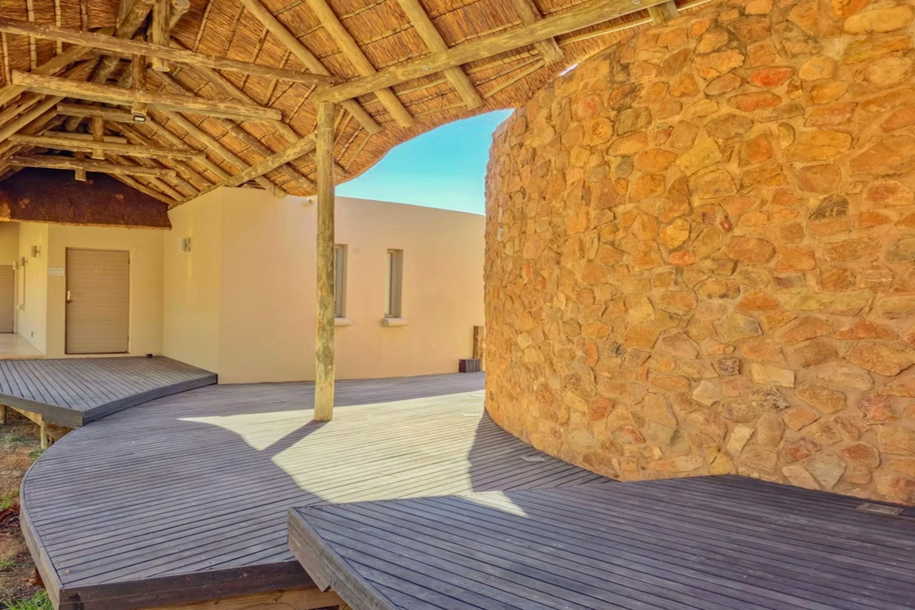 Stone-walled courtyard and timber walkway between the suites at Sithrah Private Lodge
